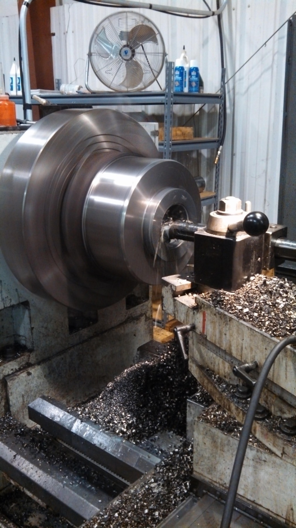 Cylinder head machining operation in progress on large industrial lathe